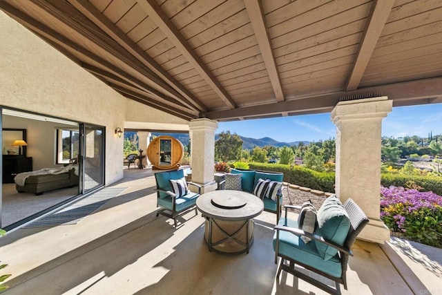 view of patio / terrace featuring a mountain view and an outdoor living space with a fire pit