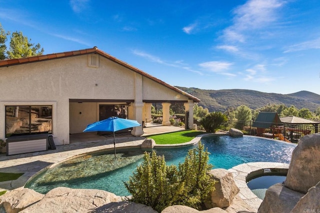 view of swimming pool with an in ground hot tub, a mountain view, and a patio