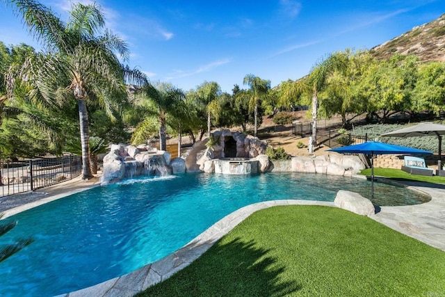 view of pool with pool water feature and a yard