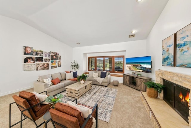 living room featuring lofted ceiling, a high end fireplace, and light colored carpet