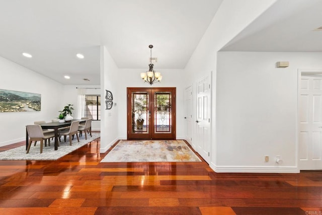 foyer entrance with an inviting chandelier, hardwood / wood-style floors, and french doors