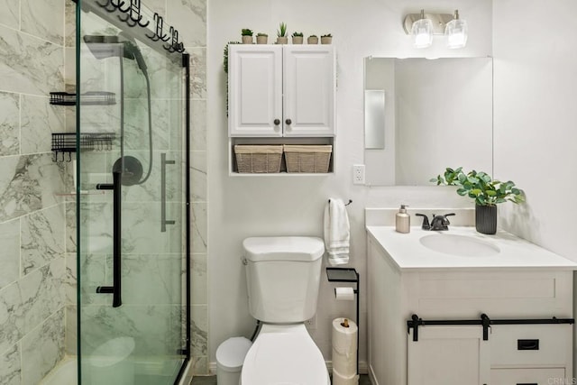 bathroom with vanity, a shower with door, and toilet