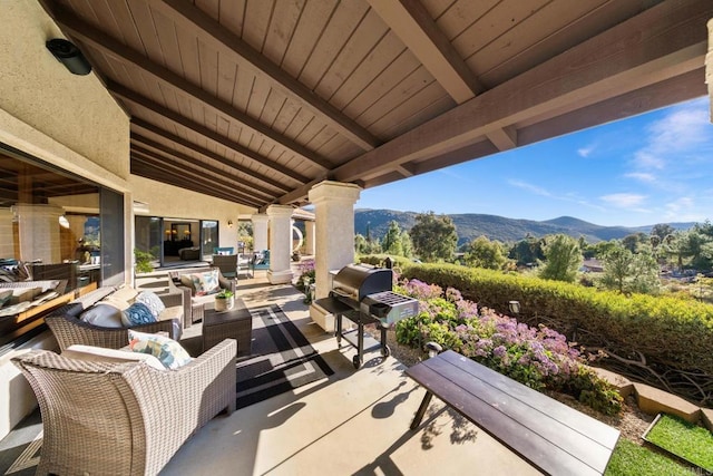 view of patio / terrace featuring an outdoor living space, a mountain view, and a grill