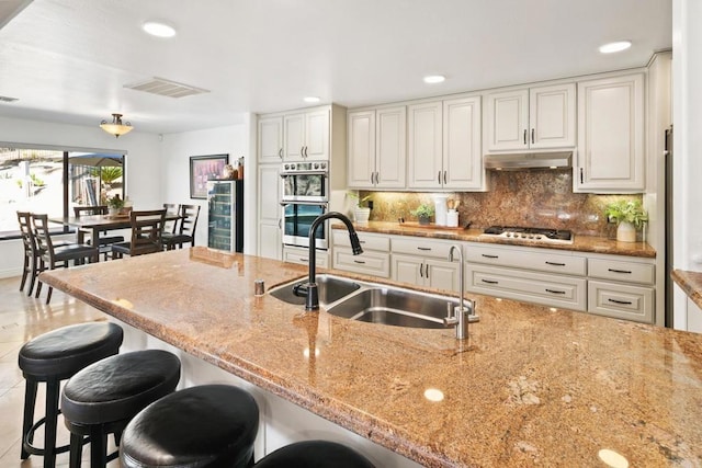 kitchen with sink, light stone countertops, and white cabinets