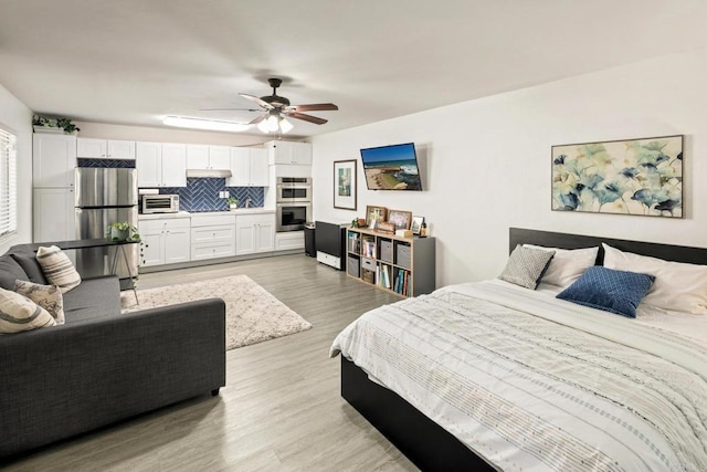 bedroom with stainless steel refrigerator, ceiling fan, and light wood-type flooring