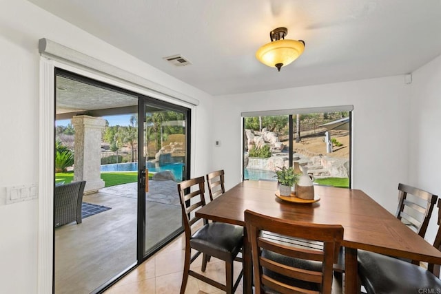 dining room with a water view, plenty of natural light, and light tile patterned flooring