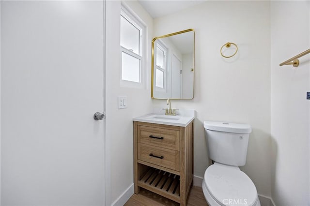 bathroom featuring vanity, hardwood / wood-style floors, and toilet