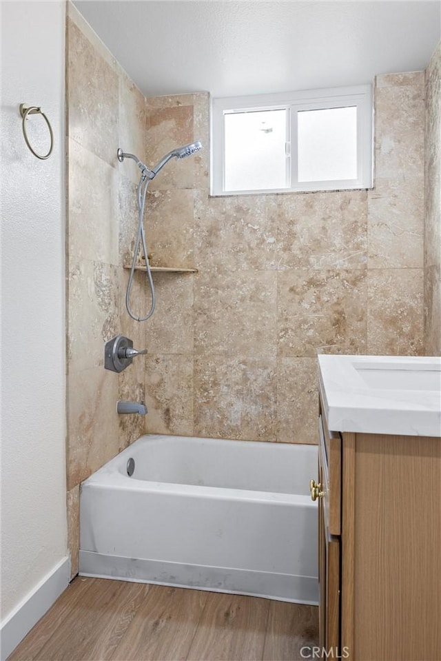 bathroom featuring vanity, wood-type flooring, and tiled shower / bath