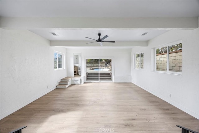 interior space with beamed ceiling, ceiling fan, and light hardwood / wood-style flooring