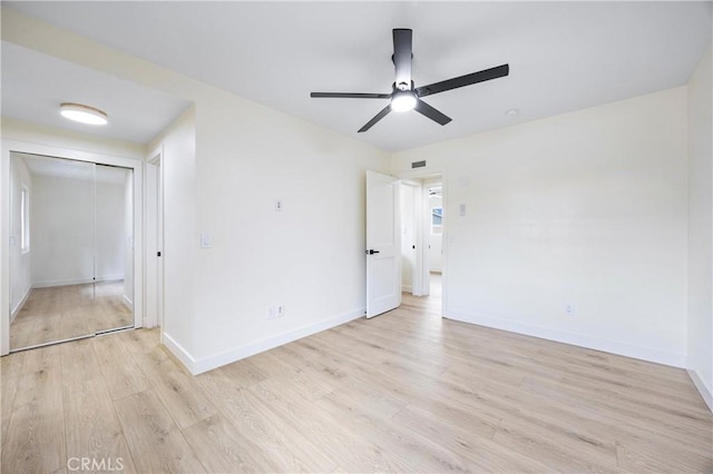 unfurnished bedroom featuring ceiling fan, a closet, and light hardwood / wood-style flooring