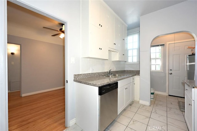 kitchen with sink, white cabinetry, stone countertops, dishwasher, and ceiling fan