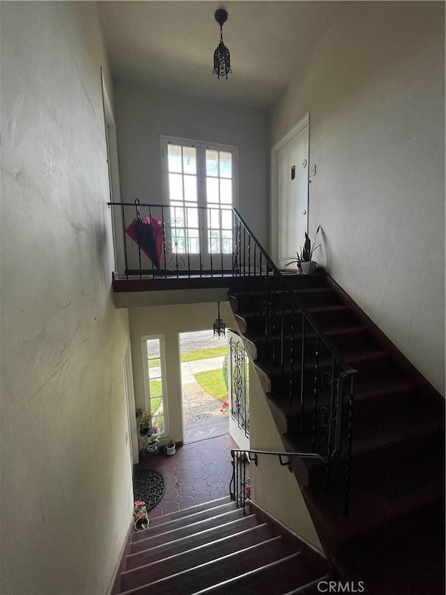 stairs featuring a high ceiling and a wealth of natural light