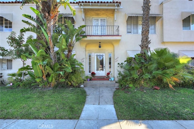 view of front of property with a balcony and a front lawn