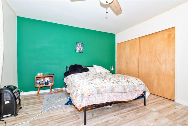 bedroom with ceiling fan, hardwood / wood-style floors, and a closet