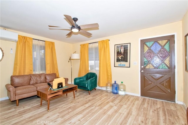 living room with ceiling fan, an AC wall unit, and light hardwood / wood-style floors