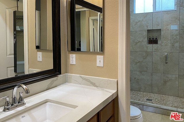 bathroom featuring vanity, toilet, and a shower with shower door