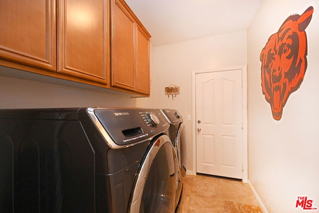 washroom featuring cabinets and washing machine and clothes dryer