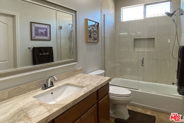 full bathroom featuring tile patterned flooring, vanity, shower / bath combination with glass door, and toilet