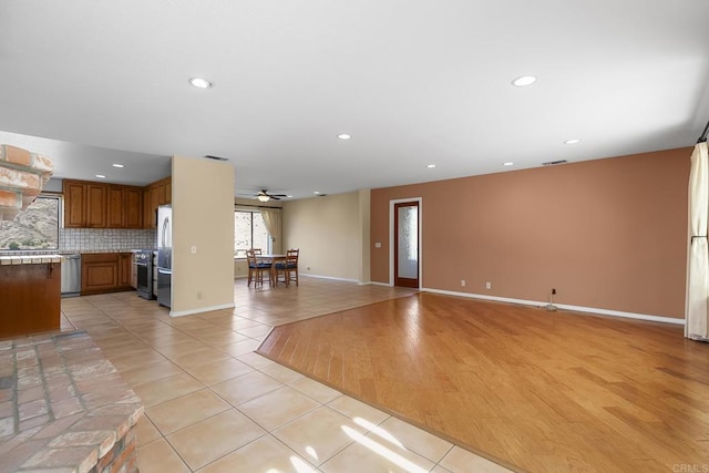 kitchen featuring tasteful backsplash, appliances with stainless steel finishes, light tile patterned floors, and ceiling fan