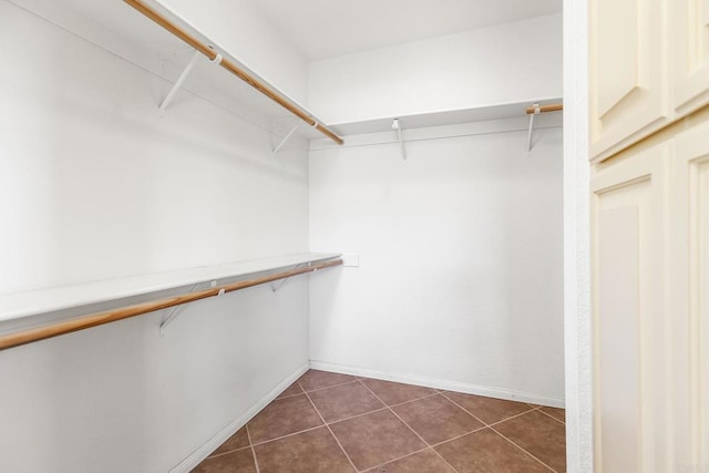 walk in closet with dark tile patterned flooring