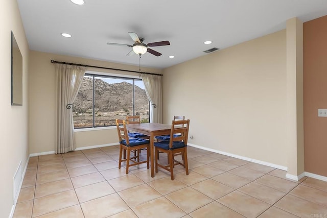 dining space with a mountain view, light tile patterned floors, and ceiling fan