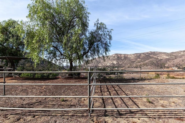 view of yard with a rural view, a mountain view, and an outdoor structure