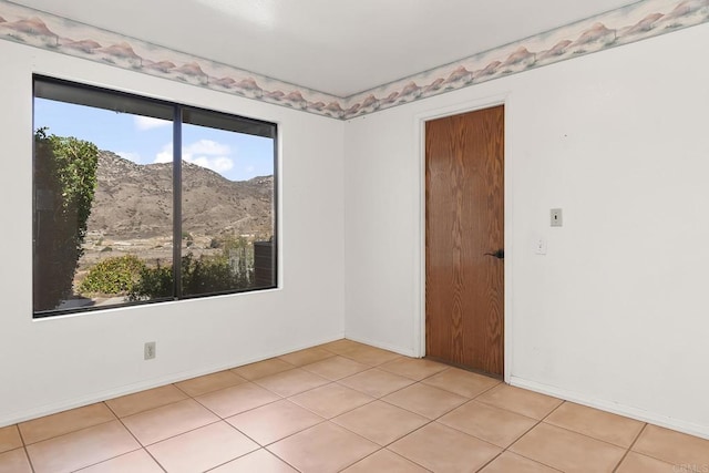 tiled spare room featuring a mountain view