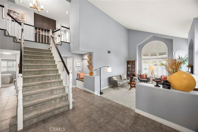 foyer featuring tile patterned floors, high vaulted ceiling, and a chandelier