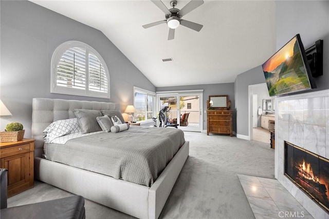 carpeted bedroom with ceiling fan, a tile fireplace, and lofted ceiling