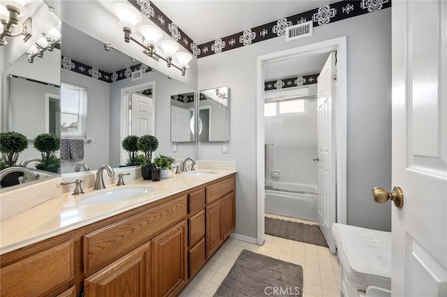 bathroom with tiled shower / bath combo and vanity