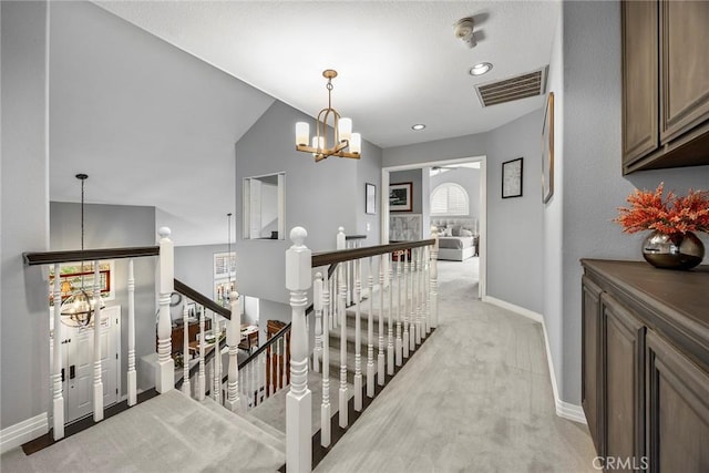 corridor featuring a chandelier and light colored carpet