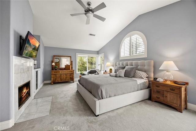 carpeted bedroom featuring vaulted ceiling, ceiling fan, and a fireplace