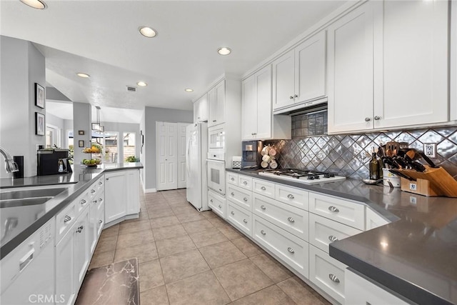 kitchen with sink, white appliances, tasteful backsplash, and white cabinets