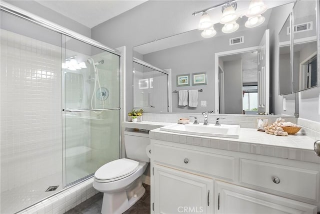 bathroom featuring an enclosed shower, vanity, and toilet