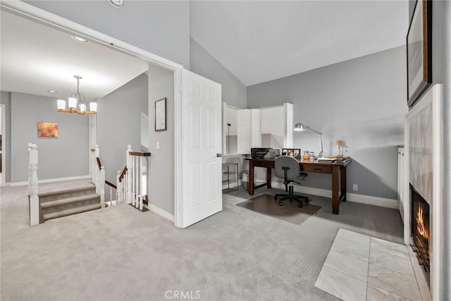 home office with a notable chandelier, a large fireplace, vaulted ceiling, and light colored carpet