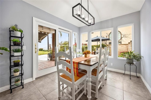 dining space with light tile patterned flooring and an inviting chandelier