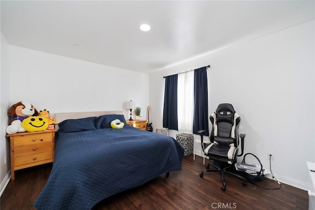 bedroom with dark hardwood / wood-style floors