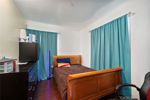 bedroom with dark hardwood / wood-style flooring