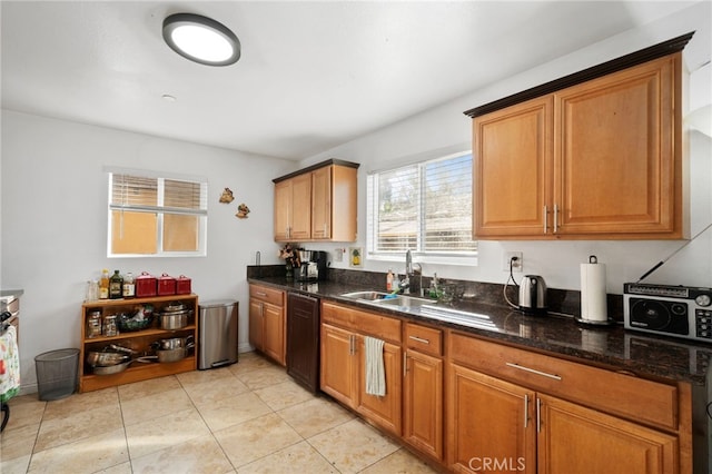 kitchen featuring black dishwasher, sink, light tile patterned floors, and dark stone counters