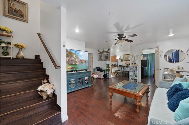 living room featuring dark wood-type flooring and ceiling fan