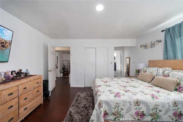 bedroom with dark hardwood / wood-style flooring and a closet