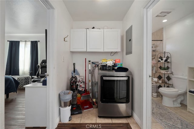 washroom featuring cabinets, washer / dryer, light tile patterned floors, and electric panel