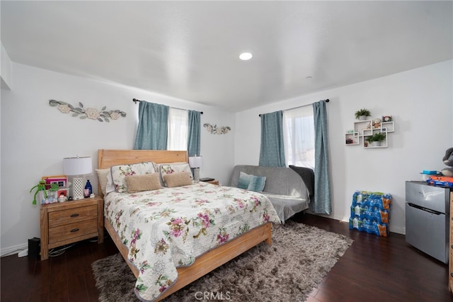 bedroom featuring dark hardwood / wood-style floors and stainless steel refrigerator