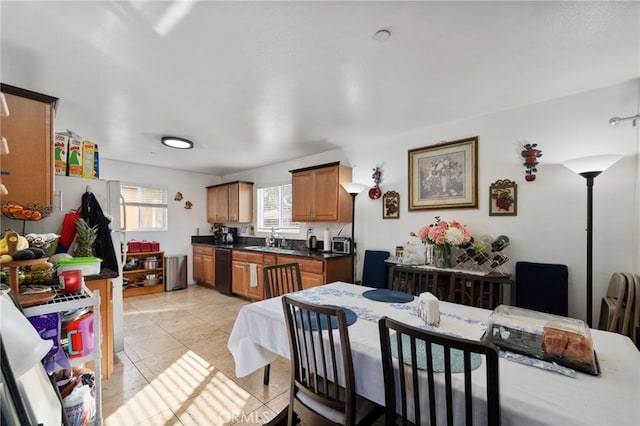 kitchen featuring light tile patterned flooring, black dishwasher, and sink