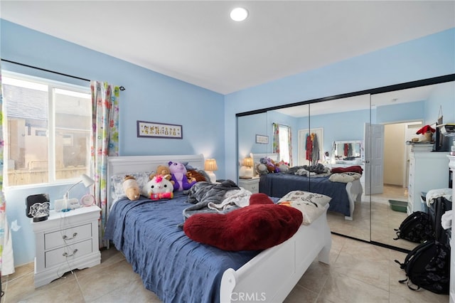 bedroom with multiple windows, a closet, and light tile patterned flooring