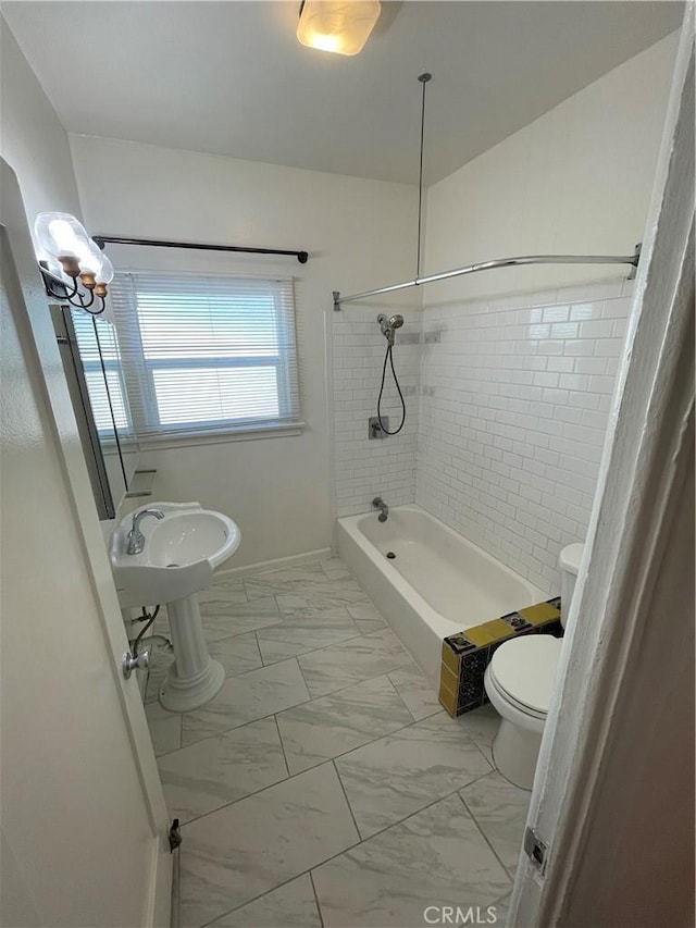 bathroom with tiled shower / bath and toilet