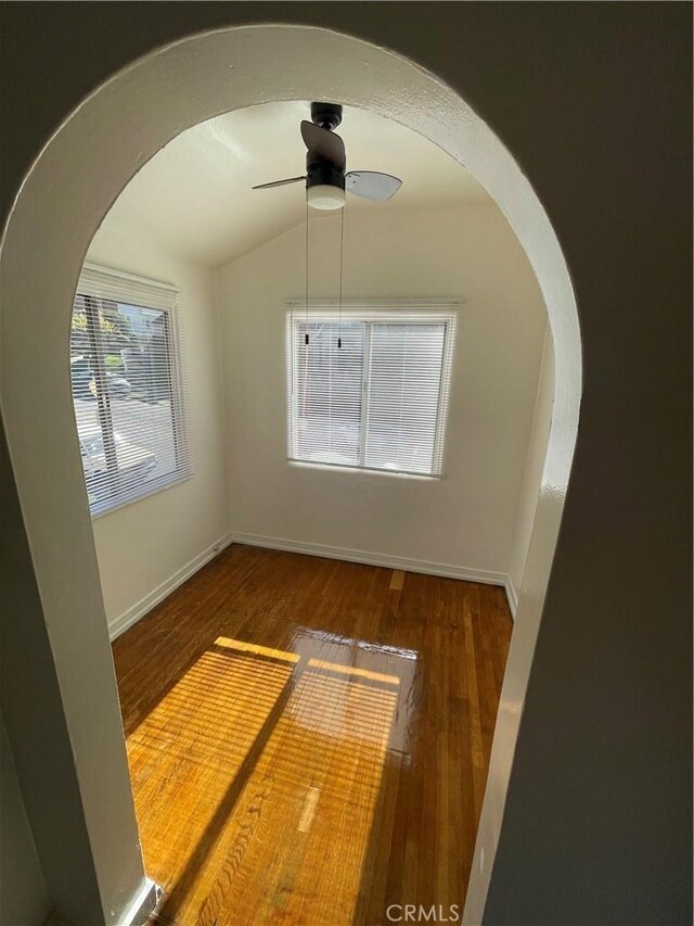 unfurnished room with ceiling fan and dark hardwood / wood-style flooring