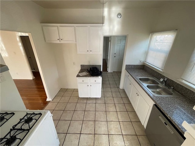 kitchen featuring sink, gas range gas stove, dishwasher, white cabinetry, and light tile patterned flooring