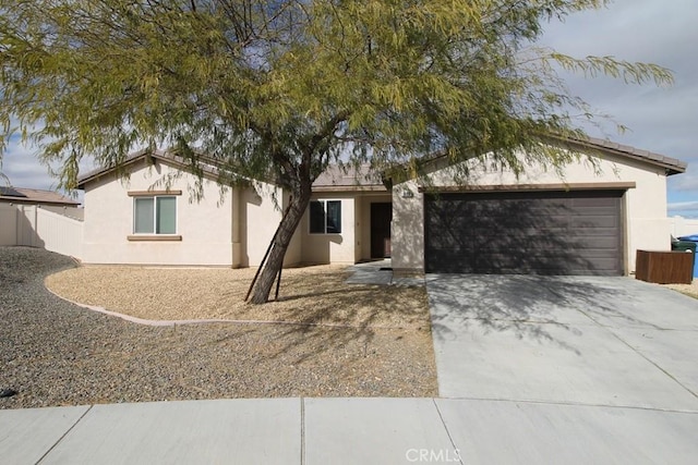 ranch-style house with a garage, driveway, and stucco siding