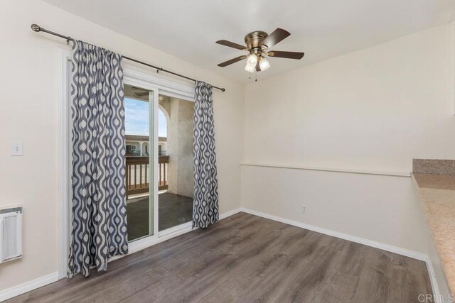 unfurnished room with dark wood-type flooring, ceiling fan, and radiator heating unit